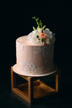 Kek koyu arkaplanda çiçeklerle süslenir..