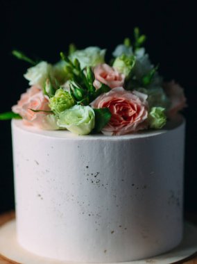 Kek koyu arkaplanda çiçeklerle süslenir..