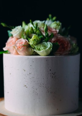 Kek koyu arkaplanda çiçeklerle süslenir..