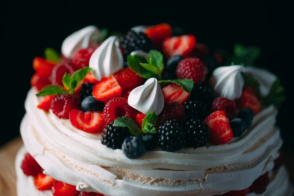 Obstkuchen. Kuchen mit Beeren auf einem Holzständer auf schwarzem Hintergrund. — Stockfoto