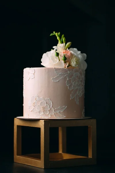 Kuchen ist mit Blumen auf dunklem Hintergrund dekoriert. — Stockfoto
