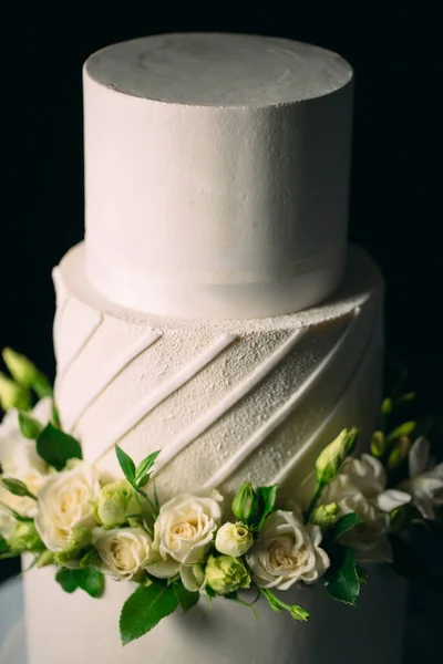 Kuchen ist mit Blumen auf dunklem Hintergrund dekoriert. — Stockfoto