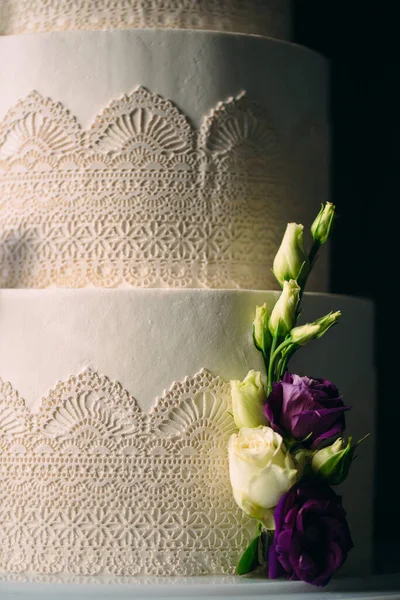 La torta è decorata con fiori su uno sfondo scuro. — Foto Stock