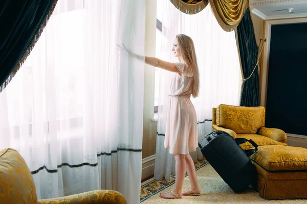 Mujeres jóvenes con maleta se alojan en una habitación de hotel. —  Fotos de Stock