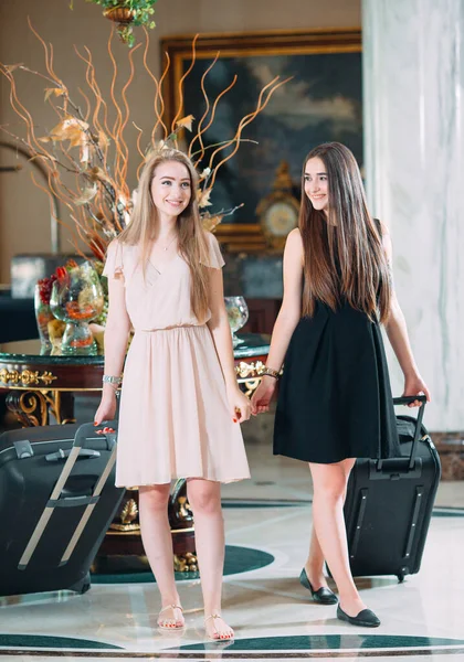 Young girls near reception desk in hotel. Young girls comes to the hotel. — Stock Photo, Image