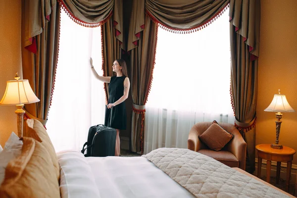 Young women with suitcase are staying in a hotel room. — Stock Photo, Image