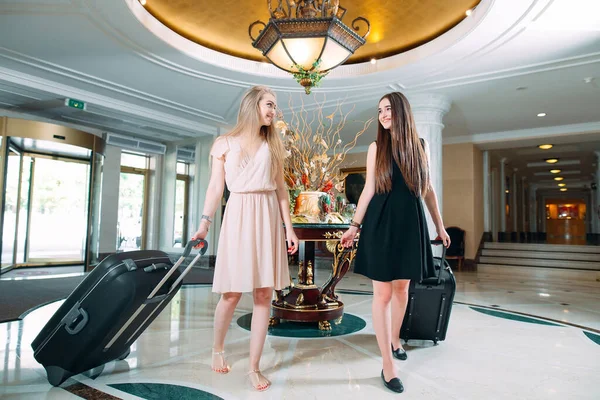 Young girls near reception desk in hotel. Young girls comes to the hotel. — Stock Photo, Image