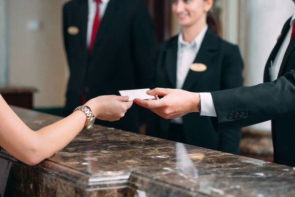 Picture of guests getting key card in hotel.