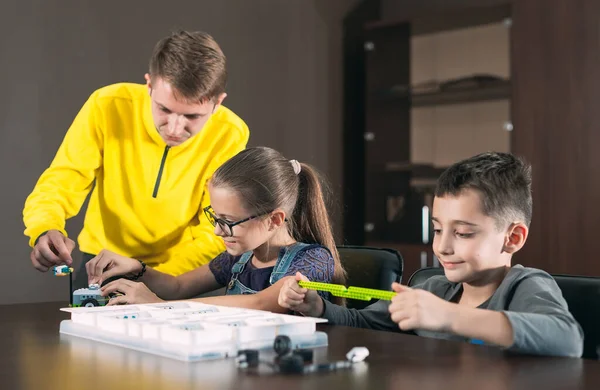 Crianças criando robôs com professor. Desenvolvimento inicial, diy, inovação, conceito de tecnologia moderna. — Fotografia de Stock