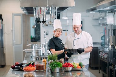 İki şef bir restoranın ya da otelin mutfağında menüyü tartışıyor..