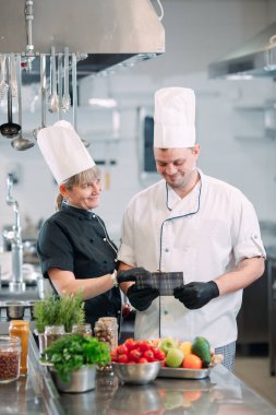 İki şef bir restoranın ya da otelin mutfağında menüyü tartışıyor..