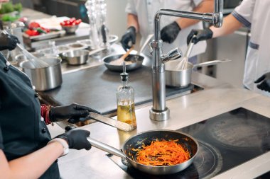 Aşçılar, restoranda ya da otelde profesyonel bir mutfakta elektrikli ocakta yemek hazırlarlar..