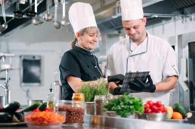 İki şef bir restoranın ya da otelin mutfağında menüyü tartışıyor..