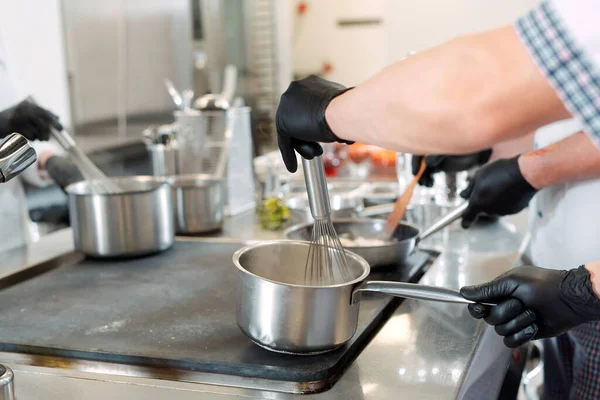 Cooks prepare meals on an electric stove in a professional kitchen in a restaurant or hotel. — Stock Photo, Image