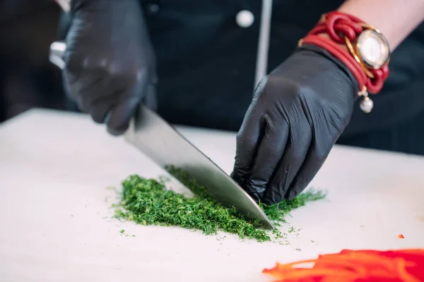 A Woman Chef cuts vegetables in the kitchen in a restaurant.