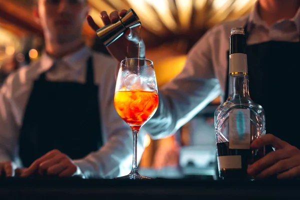 酒吧招待用勺子在吧台上搅拌着新鲜甜橙的夏季鸡尾酒. — 图库照片