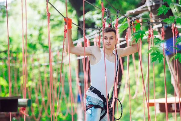 Az ember a szabadidejét kötélpályán tölti. Kötélparkban dolgozó férfi. — Stock Fotó