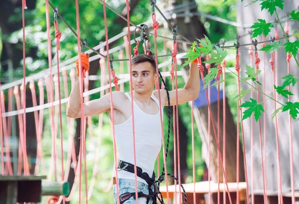 Člověk tráví svůj volný čas na laně. Muž v provazovém parku. — Stock fotografie