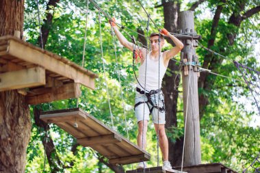 Adam boş zamanlarını ip kursunda geçiriyor. İp parkındaki adam..