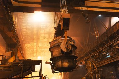 Çelik fabrikasında metalin erimesi. Eriyen ocakta yüksek sıcaklık. Metalürji endüstrisi. Metal borular üreten bir fabrika. Metali kalıplara doldurmak için kova