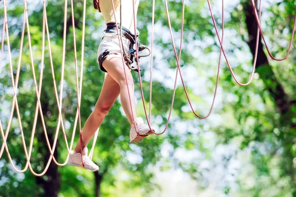 Chica joven pasar su tiempo libre en un curso de cuerdas. Chica comprometida en el parque de cuerdas — Foto de Stock
