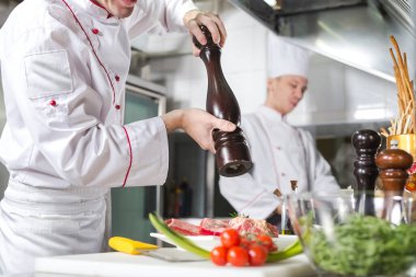 Şef restoranın mutfağında yemek hazırlıyor.