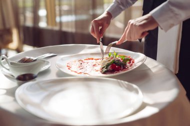 Beyaz tabakta kırmızı etli carpaccio.,