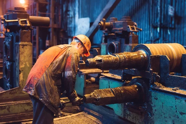 Lavoratore dell'industria pesante che lavora sodo sulla macchina. Ruvido ambiente industriale — Foto Stock