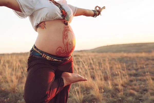 Schwangere beim Yoga auf dem Feld bei Sonnenuntergang — Stockfoto