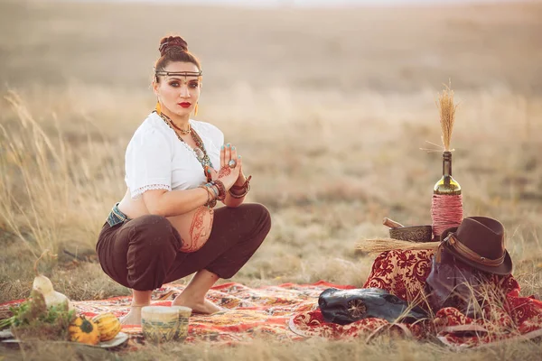 Gravid kvinna som gör yoga på fältet vid solnedgången — Stockfoto