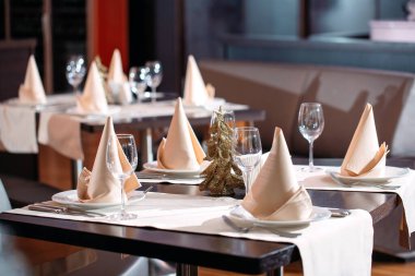 Lokantada masa ayarlandı. Arka planda Noel ağacı.