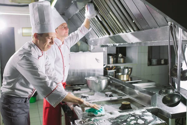 Sanitary day in the restaurant. Repeats wash your workplace. Cooks wash oven, stove and extractor in the Restaurant. — Stock Photo, Image