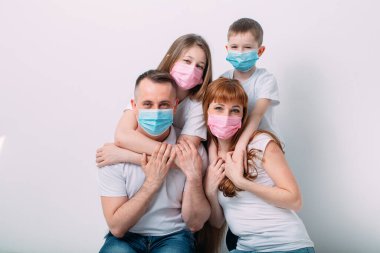 Karantina sırasında maskeli genç bir aile.