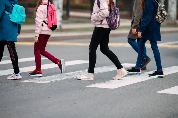 Les écoliers traversent la route avec des masques médicaux. Les enfants vont à l'école . — Photo