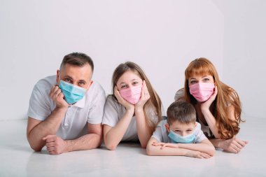 Karantina sırasında maskeli genç bir aile.