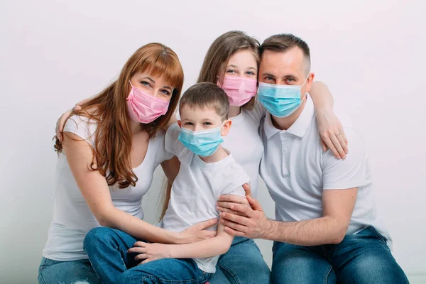 Молода сім'я в медичних масках під час домашнього карантину . — стокове фото
