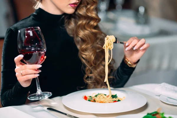 Ung vacker kvinna äter pasta i en restaurang. — Stockfoto