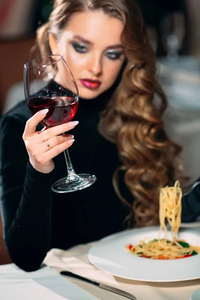 Ung vacker kvinna dricker vin på restaurang. — Stockfoto