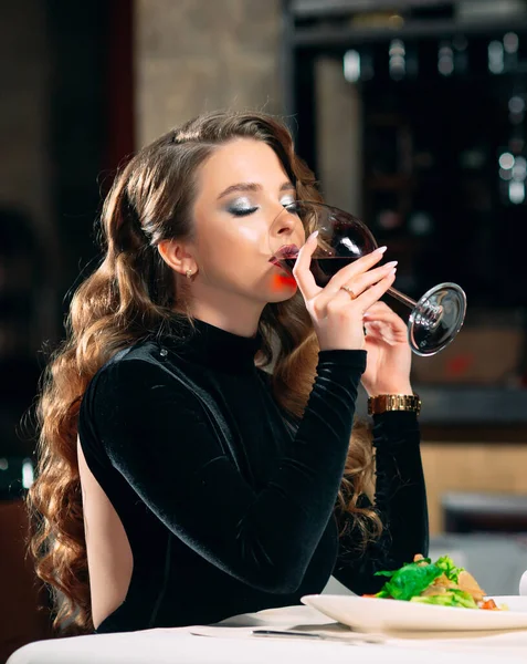Ung vacker kvinna dricker vin på restaurang. — Stockfoto