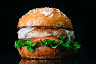 Siyah arka planda sulu sığır etli burger..