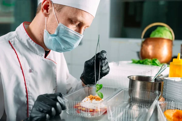 Food delivery in the restaurant. The chef prepares food in the restaurant and packs it in disposable dishes. — Stock Photo, Image