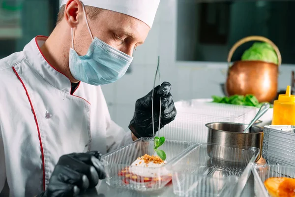 Food delivery in the restaurant. The chef prepares food in the restaurant and packs it in disposable dishes. — Stock Photo, Image