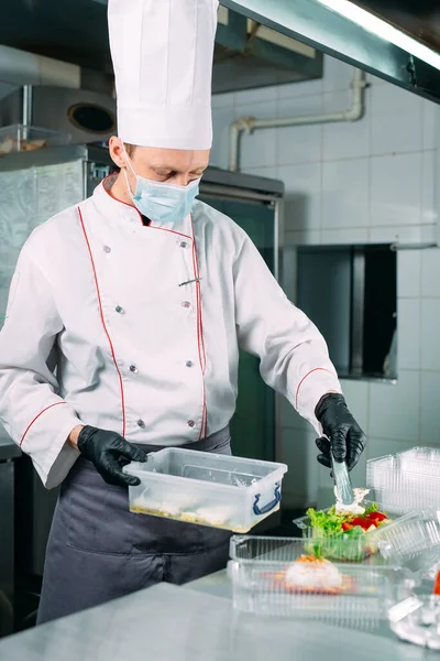 Entrega de comida no restaurante. O chef prepara comida no restaurante e a embala em pratos descartáveis. — Fotografia de Stock