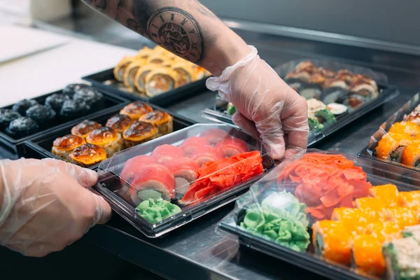 Sushi-leverans. Många sorter av sushi i en plastlåda förbereds för leverans. — Stockfoto