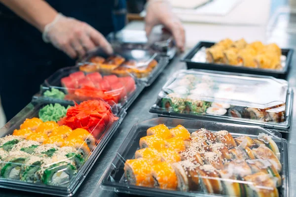 Sushi-leverans. Många sorter av sushi i en plastlåda förbereds för leverans. — Stockfoto