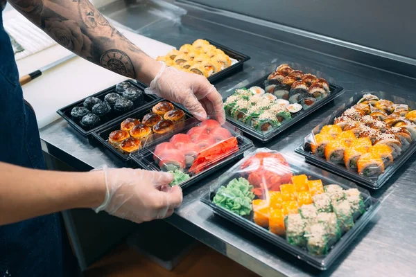 寿司の配達だ。プラスチック製の箱の中の寿司の多くの品種は配達のために用意されています. — ストック写真