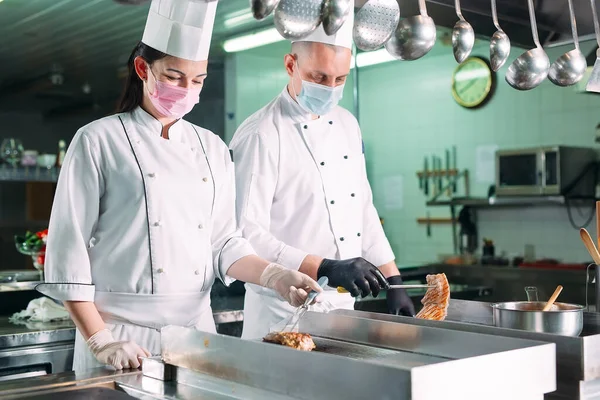 Кухарі смажать м'ясо на плиті на кухні ресторану або готелю . — стокове фото