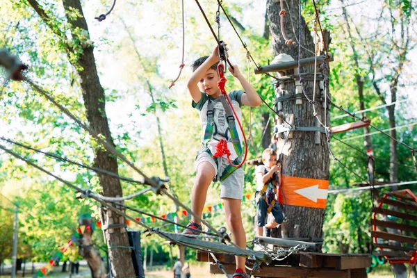 Cuerda Park. El niño pasa el obstáculo en el parque de cuerdas. — Foto de Stock