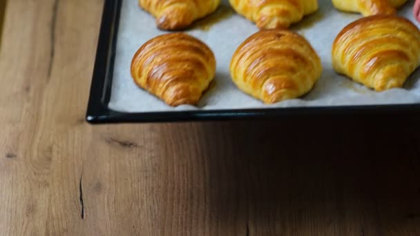 Croissants recién horneados en bandeja para hornear — Vídeos de Stock