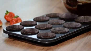 Çikolatalı hamur kabartma forma koyarak.